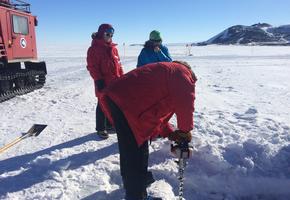 Hubert drilling into a sea ice crack to measure depth